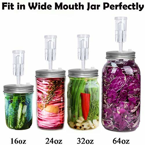 Four fermentation jars with airlocks containing pickled vegetables.