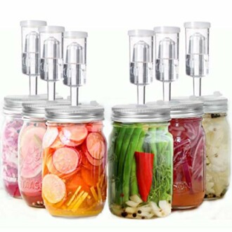 Mason jars with fermentation lids and assorted vegetables.